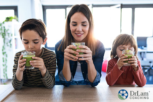 An image of a mother and her two children at the table drinking detoxifying green smoothies