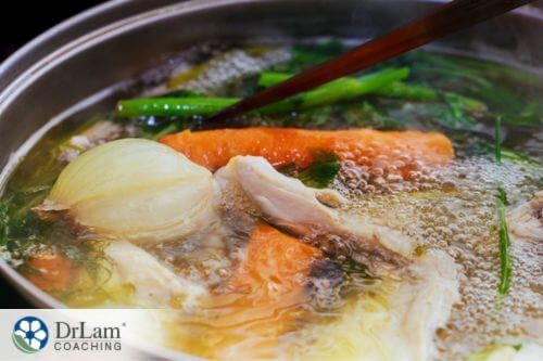 An image of chicken and vegetables boiling in a pot