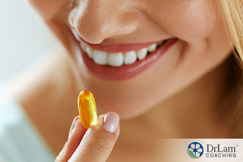 Closeup Of Beautiful Young Woman Taking the right amount of Oil Pill