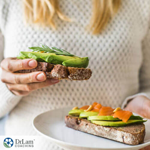 woman holding a prepared sandwich composed of ingredients rich in polyunsaturated fatty acids
