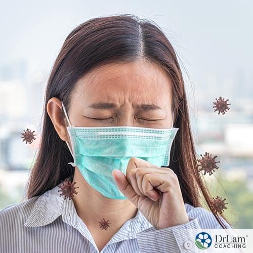 An image of a woman wearing a mask and coughing