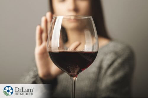 An image of a woman saying no to a glass of wine