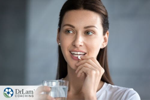 An image of a woman taking a probiotic pill