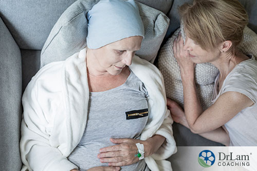 An image of two women, one a cancer patient, laying on the couch together