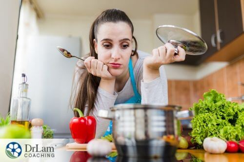 An image of a woman looking sad in her kitchen