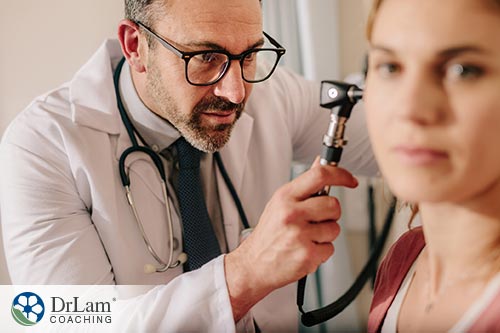 An image of a doctor looking into a woman's ear