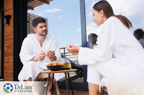 An image of a man and woman eating lunch together in white robes