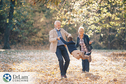 An image of an older couple and their grandson playing outdoors