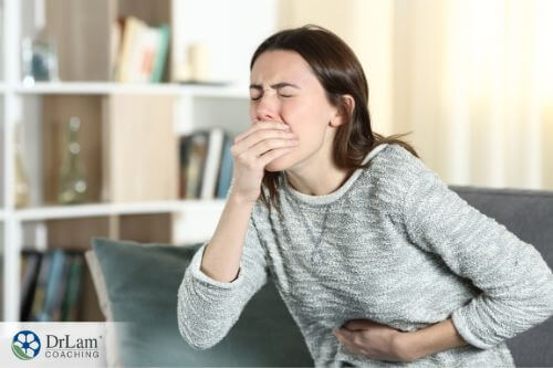An image of a woman holding her mouth like she is about to throw up