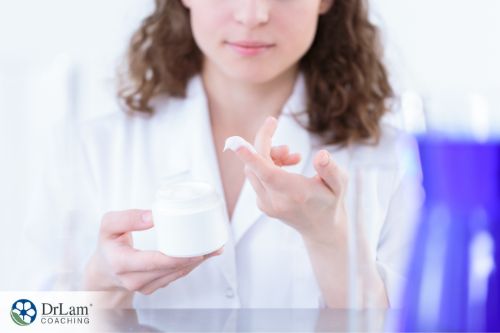 An image of a woman dipping her finger into skincare cream