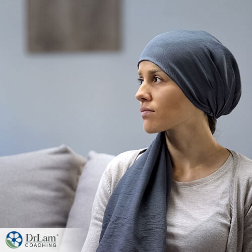 woman with cancer thinking of something while sitting on the couch