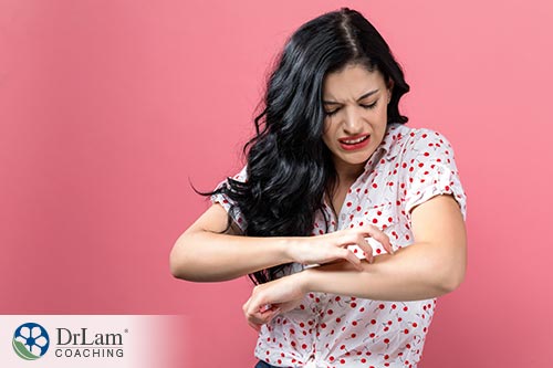 An image of a woman scratching her arm because of a soy sauce allergy or gluten sensitivity