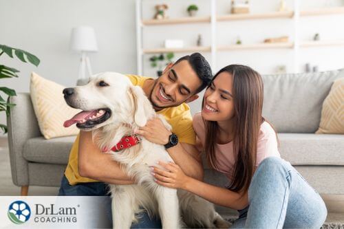 An image of a man and woman petting a dog
