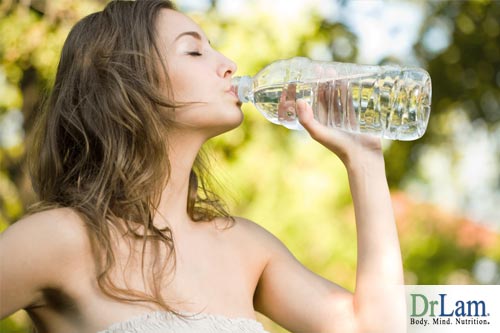 A woman drinking water from a bottle, indicating proper hydration can help with Adrenal Fatigue symptoms
