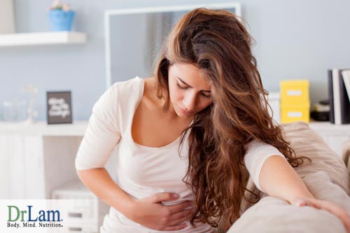 A young woman experiencing stomach discomfort, one of the D-Ribose side effects