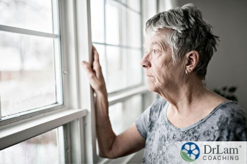 An image of an older woman staring out of a window