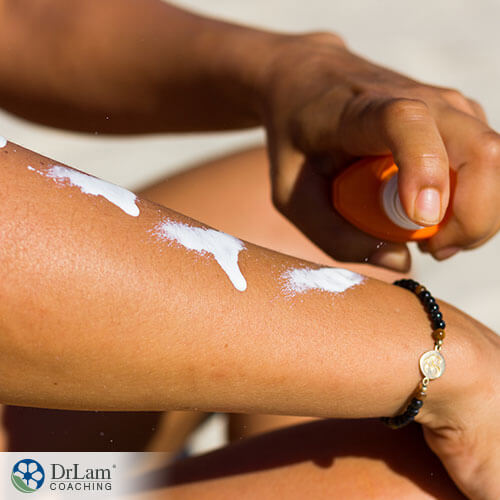 An image of someone putting sunscreen on their arms
