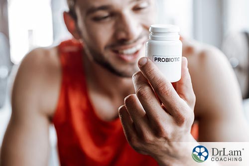 An image of man holding a bottle of probiotics
