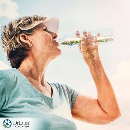 An image of a woman drinking water with herbs