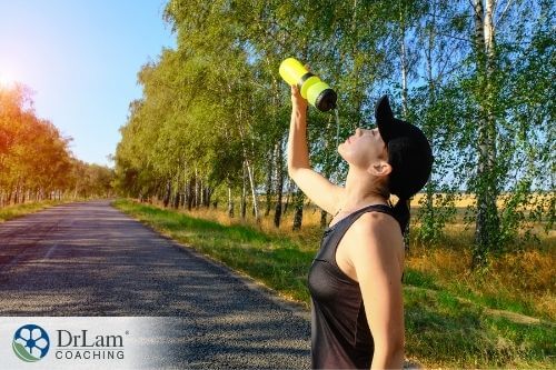 An image of a woman drinking water out of a sports bottle