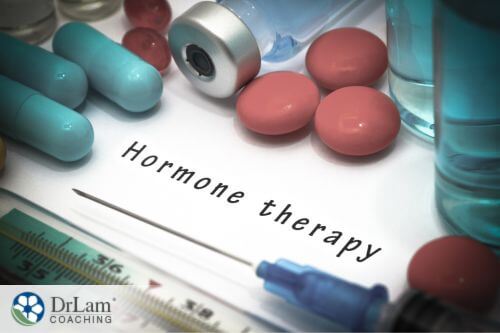 An image of the words hormone therapy surrounded by pills and injection supplies