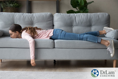 An image of a fatigued woman laying on the couch