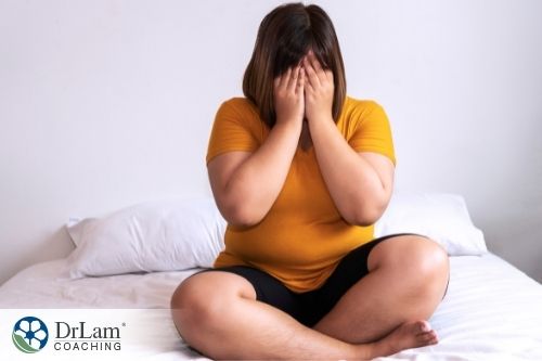 An image of a lady crying on top of the bed