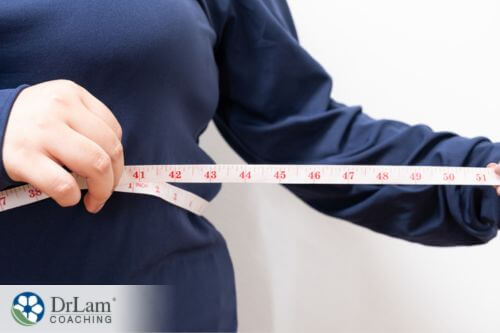 An image of a woman measuring her waist circumference