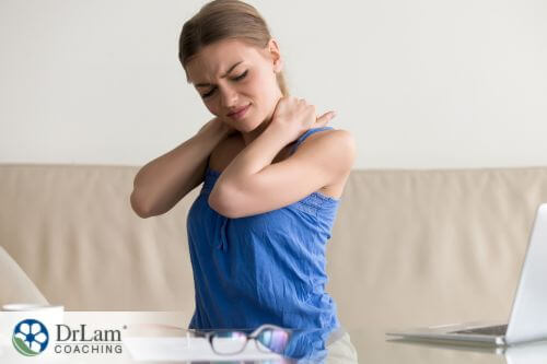 An image of a woman holding her neck in discomfort