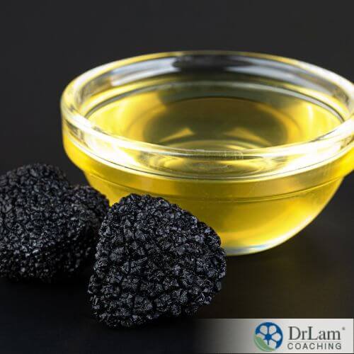 An image of black truffles and a glass bowl of oil