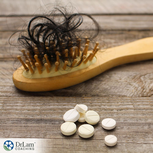 An image of some supplements next to a wooden brush with a lot of hair in the bristles