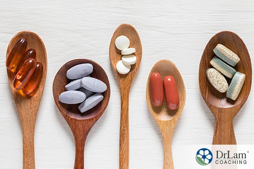 An image of five wooden spoons with different vitamins in them