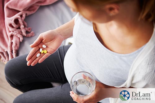 An image of a pregnant woman taking her vitamins