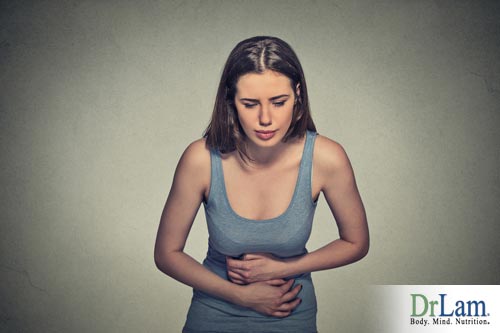 This woman is bent down and clutching her stomach. She may have adrenal fatigue and IBS.
