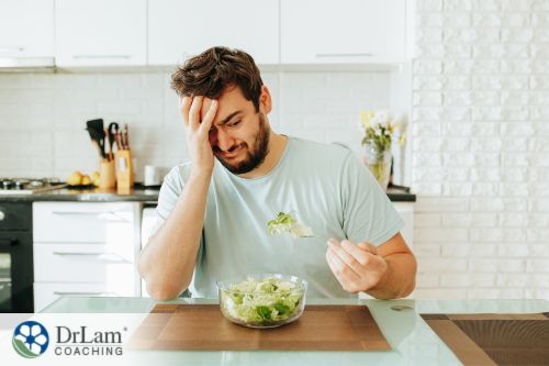 An image of a man looking grossed at a bowl of salad