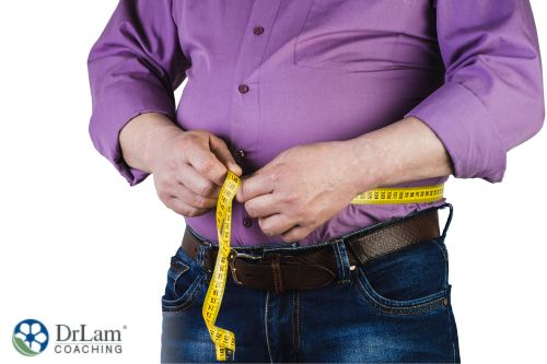 An image of a man measuring his waist